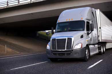 big rig driving under bridge