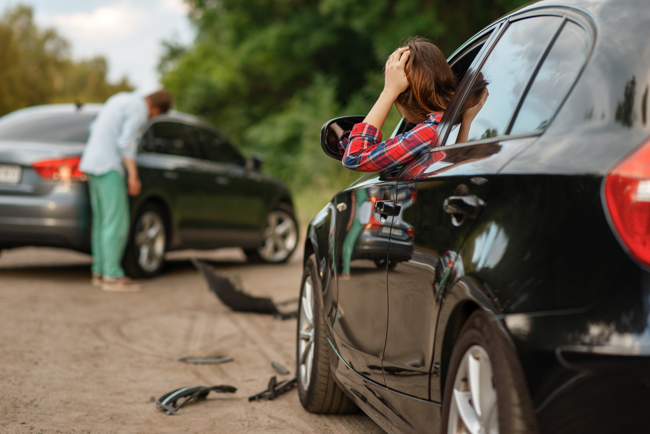 Driver reviewing damage to vehicle after an accident.